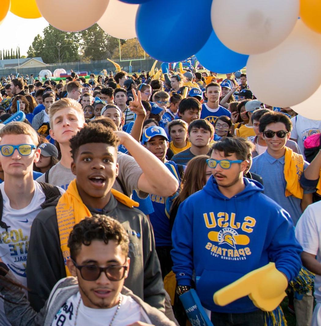 Students and staff hold Spartan Supporting Spartans pennant banners.